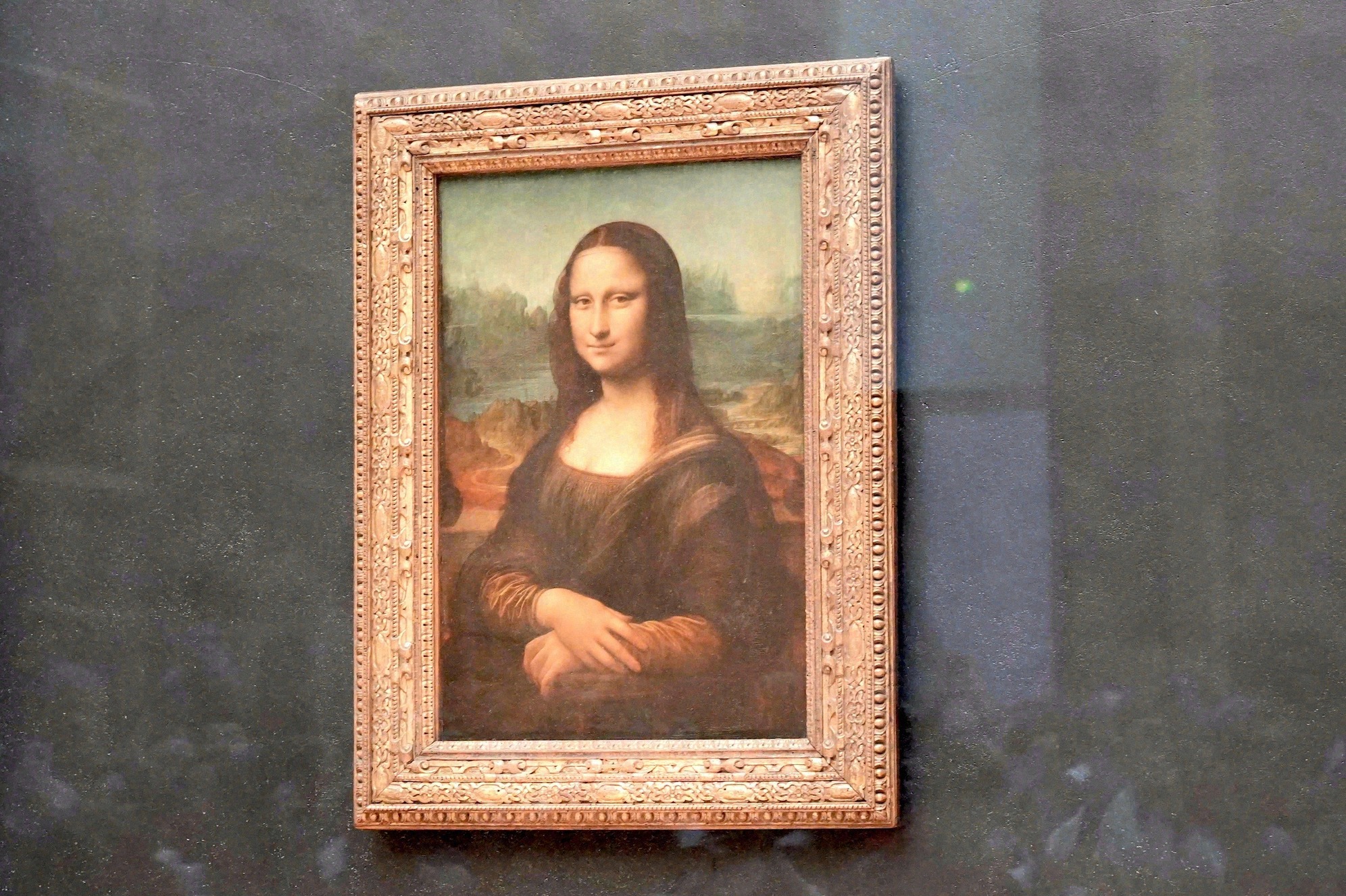Leonardo da Vincin Mona Lisa esillä lasin takana Louvressa, Pariisissa.